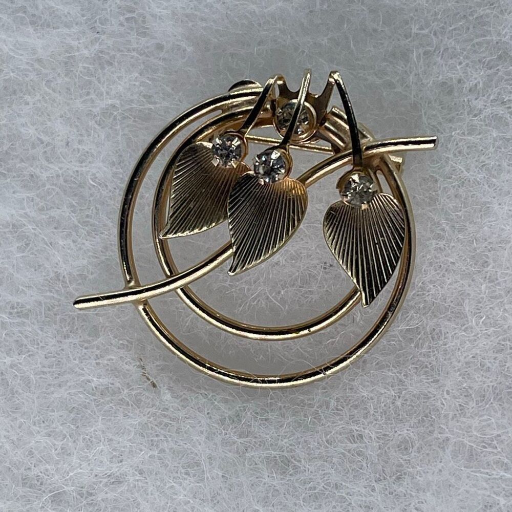 Vintage leaf and rhinestone Midcentury circular open work brooch.